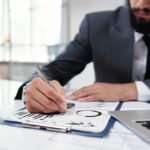 businessman writing on clipboard closeup SMEP6T5 Hotel Paradise DLX